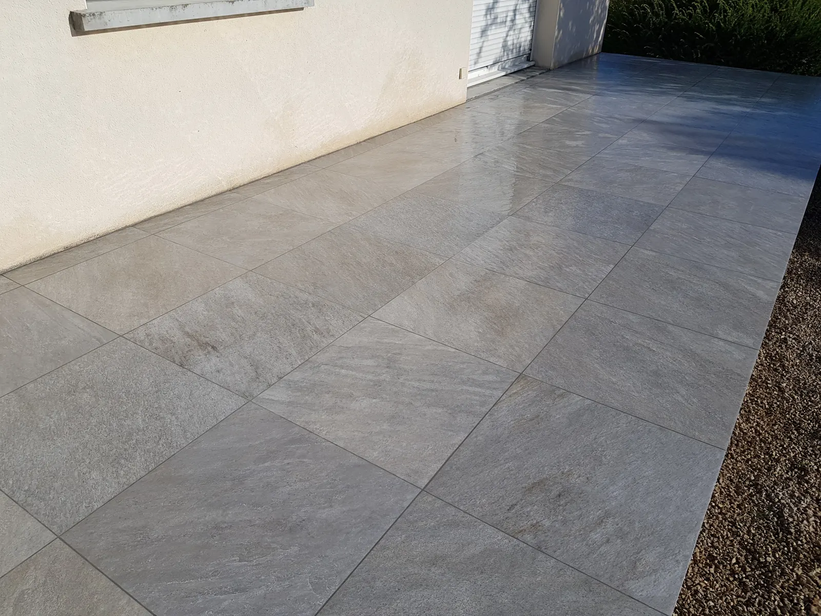 Terrasse extérieure en grès cérame clair à grands carreaux